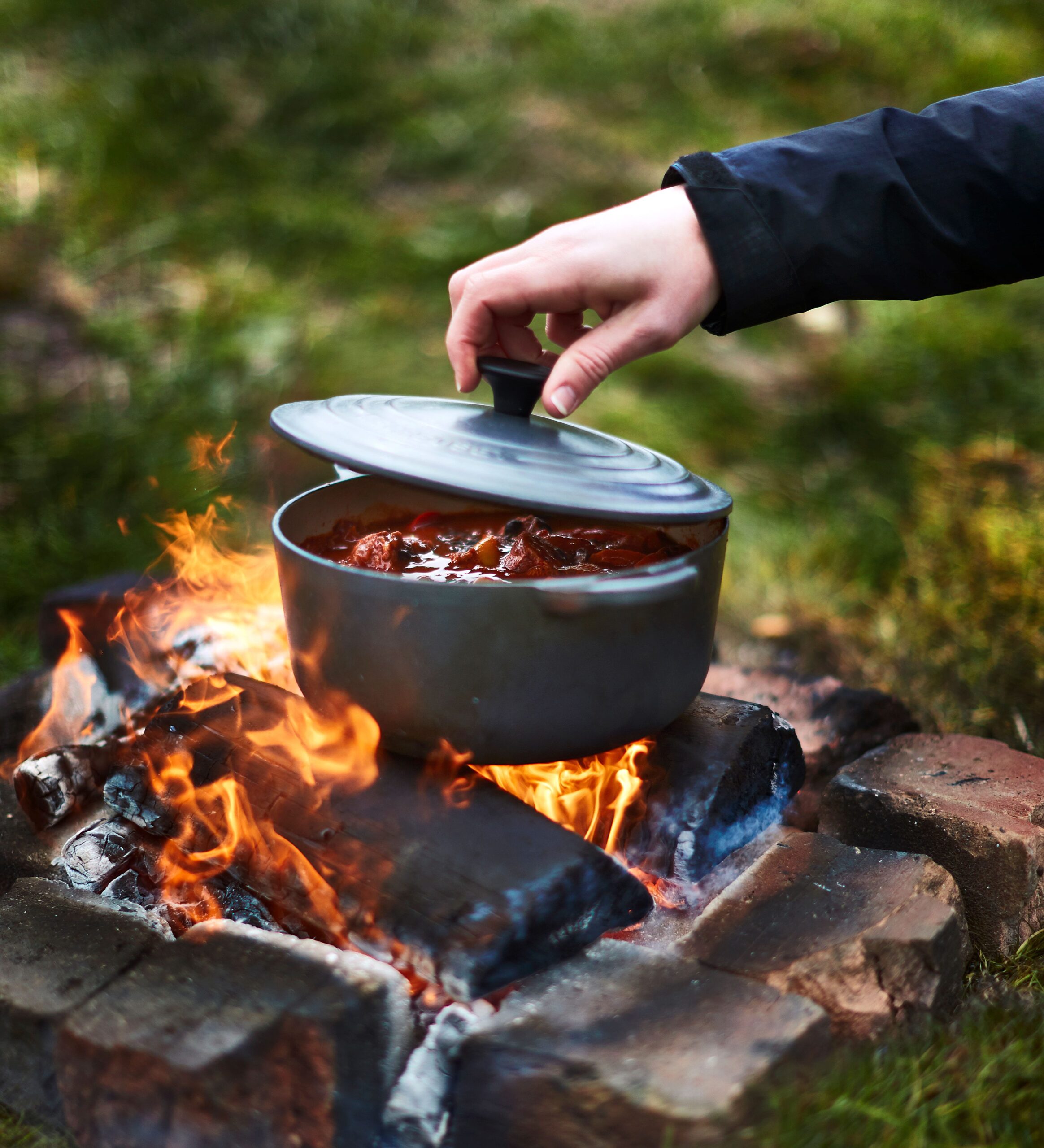 Cook over a Campfire. Camping food. The Wild Cooking. People Cooking over Fire.